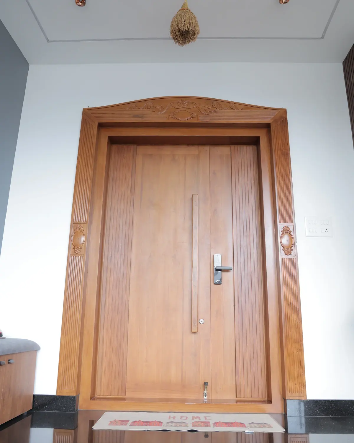 Solid teak main entrance door with 9x5 carved frame, fluted leaf, and digital lock — Sunil Residence